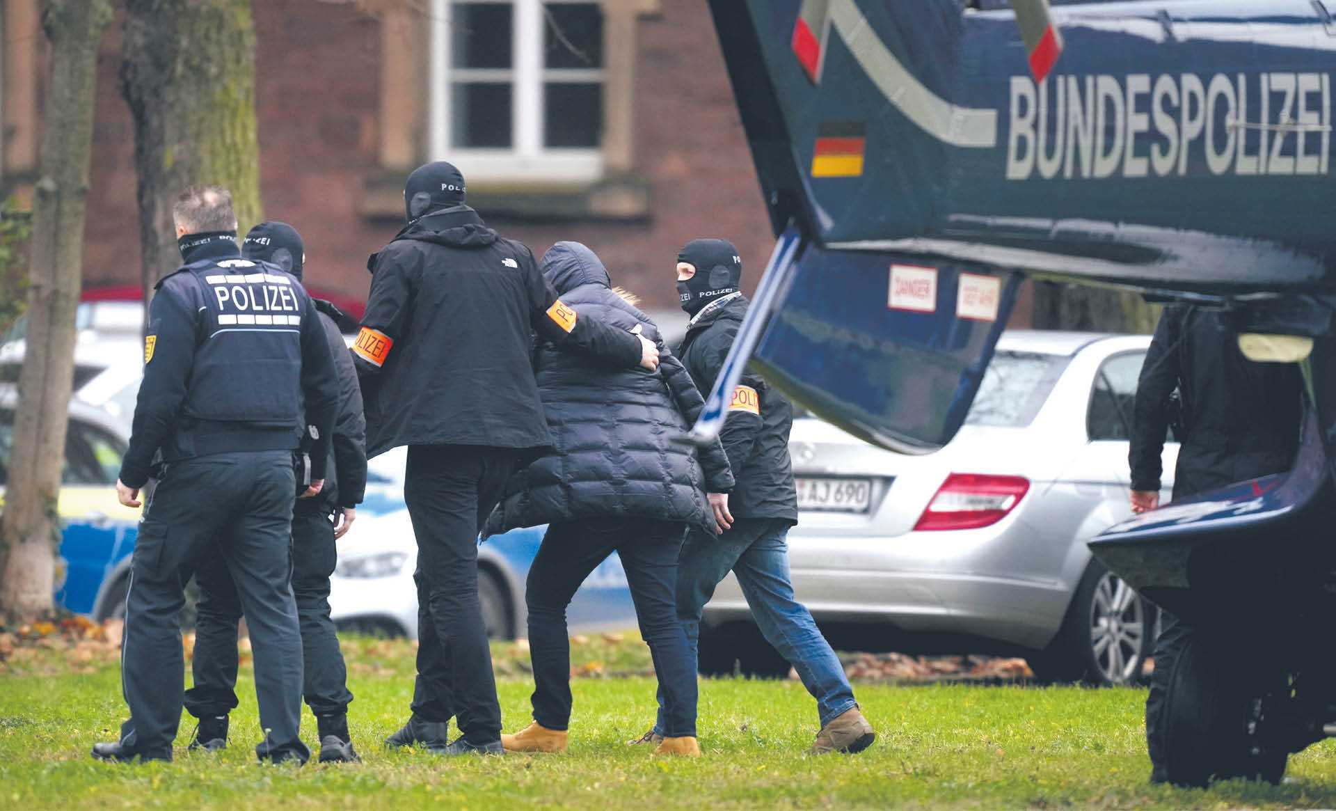 Jeden z zatrzymanych eskortowany przez policję w Karlsruhe