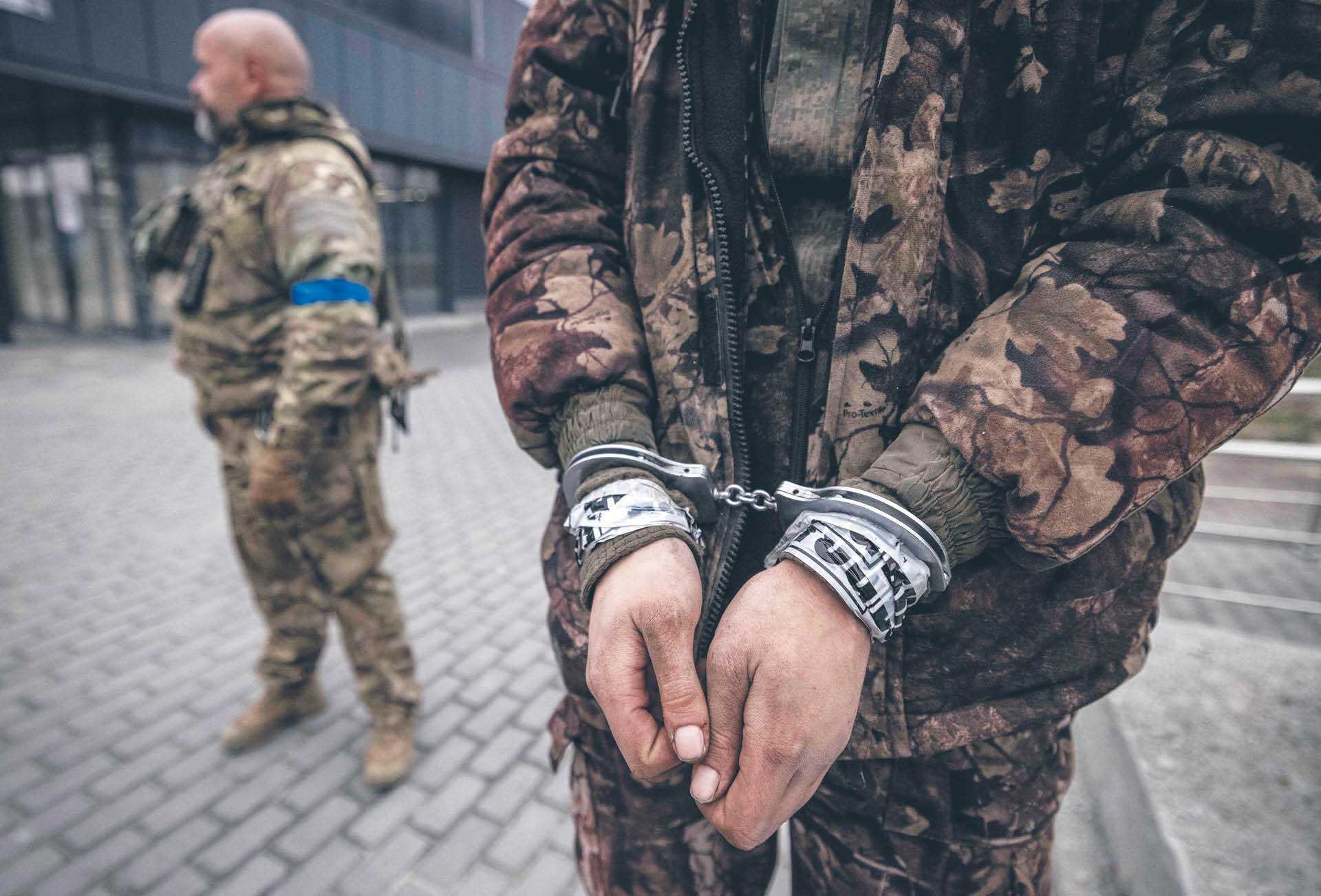 Ukraiński żołnierz eskortuje rosyjskiego jeńca na Charkowszczyźnie