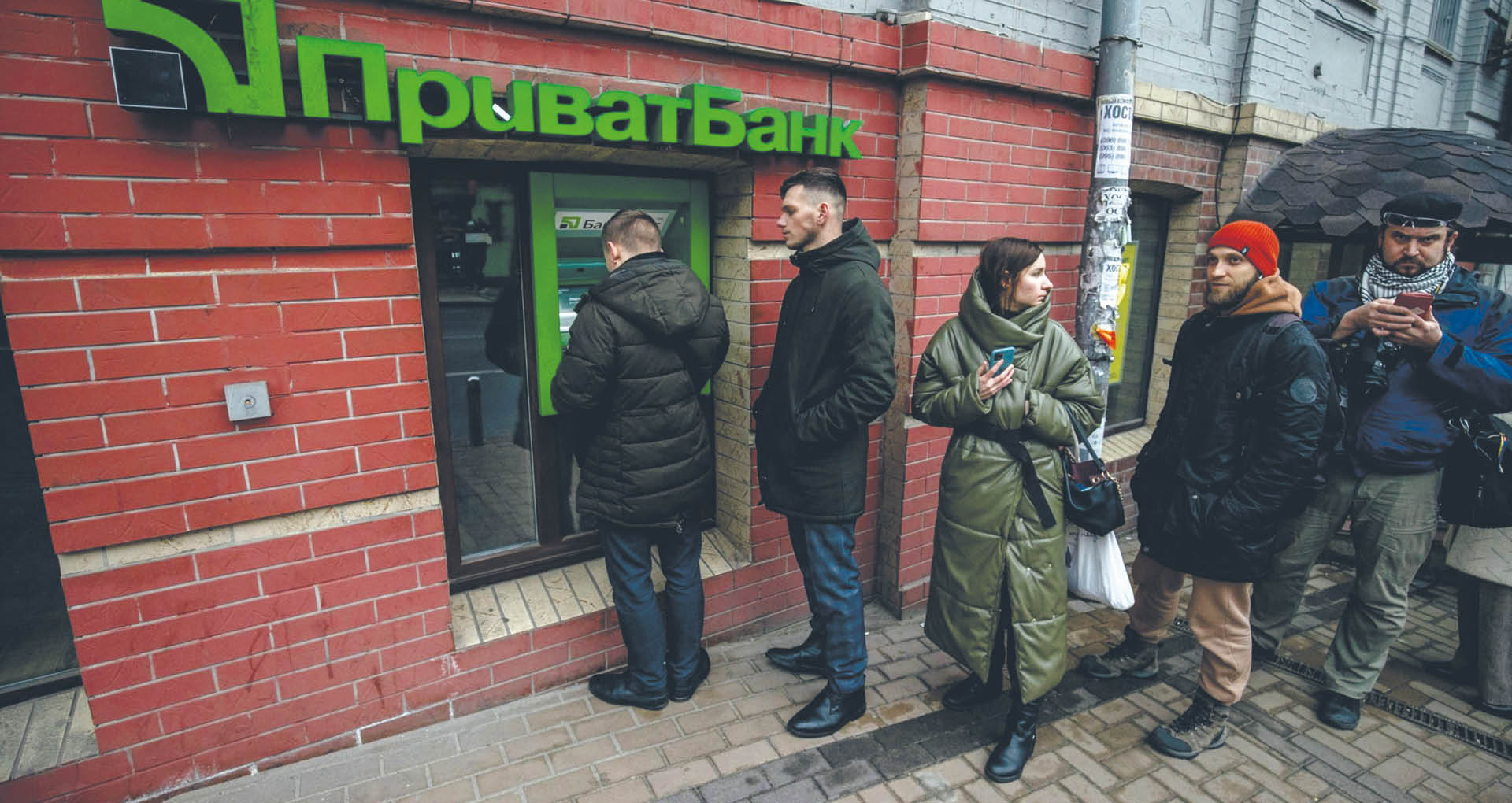 People quening at an ATM of PrivatBank, Ukraine's largest and most profitable bank, taken over by the statefrom the oligarchs a few years ago.Kyiv 24 February 2022