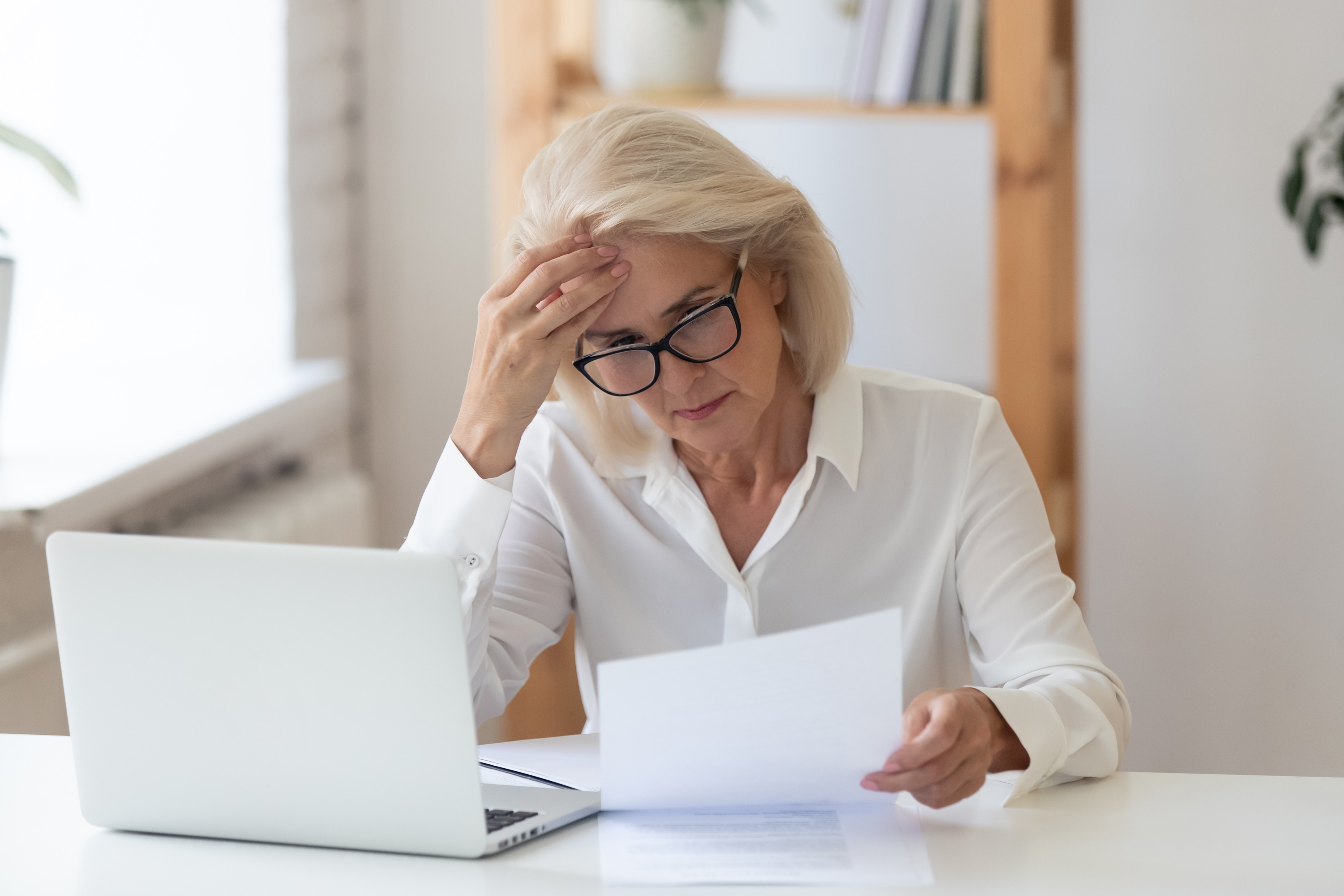 kobieta seniorka laptop dokument smutek zmartwienie